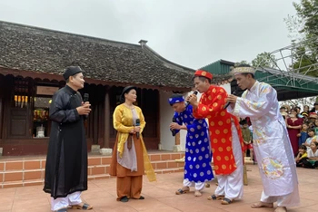 Người dân làng Quỳnh tái hiện câu chuyện “Ông đồ Nghệ và con cá gỗ”.