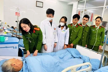 Thành viên đoàn công tác ân cần hỏi thăm sức khỏe bệnh nhân.