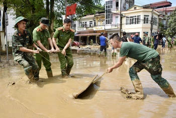 Các lực lượng quân đội và công an giúp nhân dân dọn dẹp vệ sinh môi trường sau bão lũ tại thành phố Yên Bái (Ảnh: TRẦN HẢI).