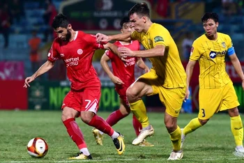 Pha bóng giữa cầu thủ đội Viettel FC (áo đỏ) và đội Sông Lam Nghệ An. (Ảnh TRẦN HẢI)