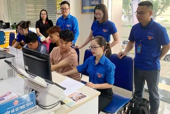 Đoàn viên, thanh niên tỉnh Bắc Kạn hướng dẫn người dân sử dụng các dịch vụ công qua điện thoại di động. (Ảnh THU TRANG)