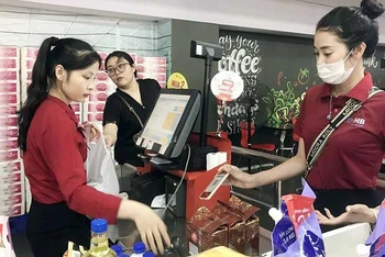 Nhân viên thu ngân đóng gói và thanh toán cho khách hàng tại siêu thị Winmart.