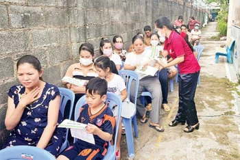Cán bộ Hội Nông dân phường Linh Trung, thành phố Thủ Đức phát tờ rơi tuyên truyền về Luật Cư trú cho công dân trên địa bàn.