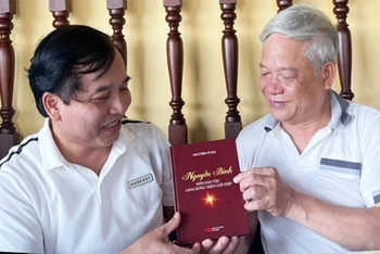 Nhà thơ Nguyễn Sĩ Đại tặng cuốn sách “Nguyễn Bính, hồn dân tộc sáng bừng trên giấy điệp”. (Ảnh: Đại biểu nhân dân tỉnh Nghệ An)