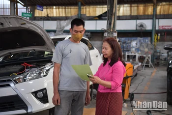 Chị Nit đang chỉ đạo nhân viên trong xưởng sửa xe của mình.