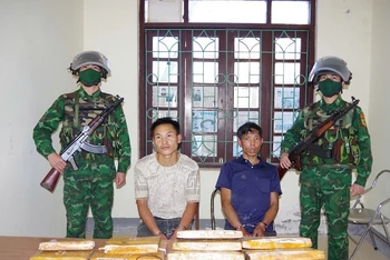 Hai đối tượng gồm: Mùa A Nhà, Mùa A Pha cùng tang vật khi bị bắt. (Ảnh: ANH DŨNG)