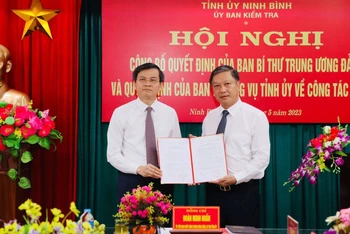 Đồng chí Đoàn Minh Huấn, Ủy viên Trung ương Đảng, Bí thư Tỉnh ủy Ninh Bình trao Quyết định của Ban Bí thư Trung ương Đảng cho đồng chí Đinh Việt Dũng. (Ảnh: ĐỨC LAM)
