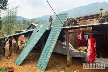 Lực lượng dân quân tự vệ và thanh niên hỗ trợ người dân sửa chữa lại nhà cửa.
