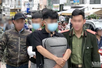 Hai đối tượng phát "danh thiếp lạ" nhằm chiếm đoạt tài sản trên không gian mạng bị lực lượng chức năng bắt quả tang. (Ảnh: Công an cung cấp)