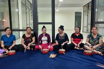Nghệ nhân trống hội Nguyễn Thị Minh Tám (người thứ tư từ trái sang) miệt mài truyền dạy cho các hội viên Câu lạc bộ trống hội phường Nghĩa Đô, quận Cầu Giấy.