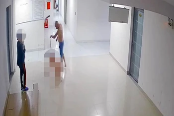 Luân dùng dây thắt lưng kéo con trai bò trong chung cư. (Ảnh cắt từ video).