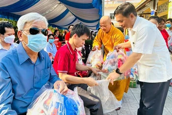 Đồng chí Nguyễn Văn Lộc, Chủ tịch Hội đồng nhân dân tỉnh, Trưởng Ban Dân vận Tỉnh ủy, Chủ tịch Ủy ban Mặt trận Tổ quốc Việt Nam tỉnh Bình Dương và Hòa thượng Thích Huệ Thông trao tặng quà cho người khiếm thị tại phiên chợ.