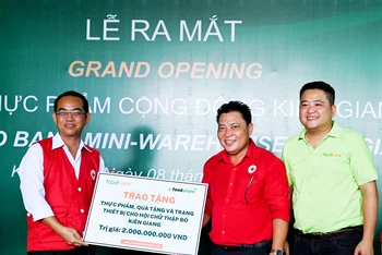 Đại diện Food Bank Việt Nam trao biển tượng trưng tặng thực phẩm, quà tặng và trang thiết bị trị giá 2 tỷ đồng đưa vào vận hành kho thực phẩm cộng đồng Kiên Giang.