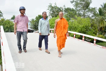 Ông Danh Hùng (giữa) đi trên cầu bê-tông do chính ông thiết kế và xây dựng.