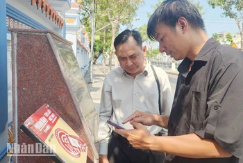 Kỹ sư lắp đặt thiết bị công nghệ hướng dẫn người dân trải nghiệm tại Di tích lịch sử quốc gia Mộ và Đình Nguyễn Trung Trực.