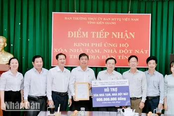 Lãnh đạo và nhân viên Công ty Điện lực Kiên Giang trao bảng tượng trưng hỗ trợ kinh phí xóa nhà tạm, nhà dột nát cho các hộ nghèo và hộ có hoàn cảnh khó khăn về nhà ở trên địa bàn tỉnh Kiên Giang.
