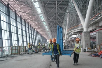 Công nhân tăng tốc thi công khu vực phòng chờ ra máy bay, công trình Nhà ga T3, Sân bay Tân Sơn Nhất ngày 27/12. (Ảnh: THẾ ANH)
