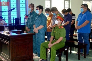 Bị cáo Luyện Xuân Tràng (đứng hàng đầu, đeo kính), chủ mưu vụ án buôn lậu xăng dầu, cùng các bị cáo tại phiên tòa.