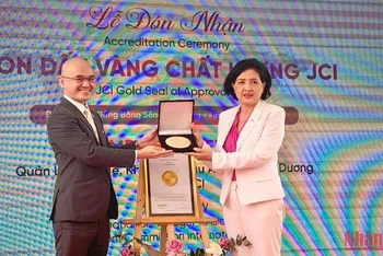Đại diện tổ chức Thẩm định quốc tế Hoa Kỳ trao chứng nhận con dấu vàng cho Bệnh viện Quốc tế Phương Châu. (Ảnh: THANH TÂM)