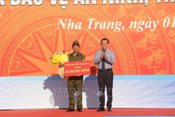 Phó Thủ tướng Chính phủ Trần Lưu Quang, Ủy viên Trung ương Đảng, Trưởng Ban Chỉ đạo 138 Chính phủ tặng quà cho đại diện Lực lượng tham gia bảo vệ an ninh trật tự ở cơ sở trên địa bàn thành phố Nha Trang. 