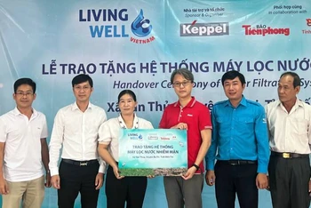Đơn vị tài trợ trao bảng tượng trưng tặng hệ thống máy lọc nước cho chính quyền địa phương.