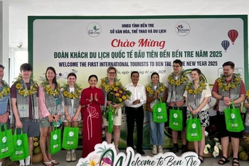 Lãnh đạo Sở Văn hóa, Thể thao và Du lịch tỉnh Bến tre tặng quà cho đoàn khách quốc tế đầu tiên đến Bến Tre năm 2025. (Ảnh: HOÀNG TRUNG)