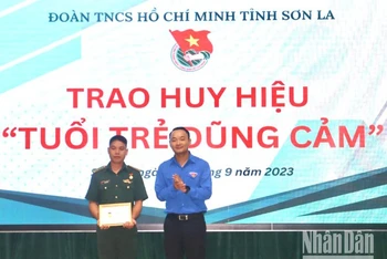 Đồng chí Nguyễn Duy Dũng, Phó Bí thư Thường trực Tỉnh đoàn Sơn La trao Huy hiệu “Tuổi trẻ dũng cảm” cho đại úy Quàng Văn Tám.