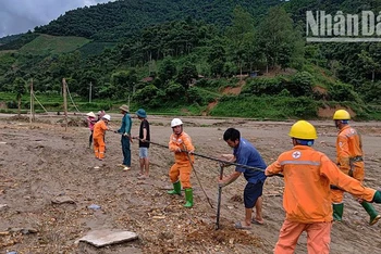 Công nhân Điện lực khu vực Mai Sơn-Yên Châu cùng nhân dân dựng cột tạm, kéo dây cấp điện trở lại cho người dân bản Nhụng Trên.