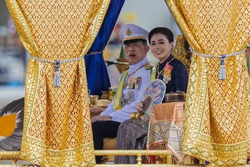 Đương kim Quốc vương Thái Lan Maha Vajiralongkorn (Vua Rama X) và Hoàng hậu Suthida ngồi trên thuyền rước hoàng gia. (Ảnh: TTXVN)