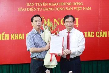 Phó Trưởng Ban Tuyên giáo Trung ương Phan Xuân Thủy trao Quyết định và tặng hoa chúc mừng đồng chí Nguyễn Công Dũng.