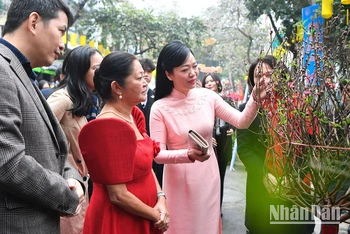 Phu nhân Chủ tịch nước Phan Thị Thanh Tâm giới thiệu với Phu nhân Tổng thống Philippines Louise Araneta Marcos về ý nghĩa của cành hoa đào ngày Tết.
