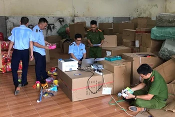 Lực lượng chức năng kiểm tra hàng hóa tại kho chứa hàng của hộ kinh doanh vi phạm.
