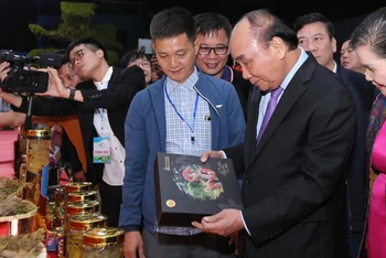 Chủ tịch nước Nguyễn Xuân Phúc thăm quan các gian hàng của Hiệp hội sâm Lai Châu tại hội chợ.