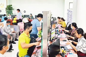 Cán bộ Văn phòng đăng ký đất đai thành phố Thủ Ðức làm thủ tục hồ sơ nhà đất cho người dân. 