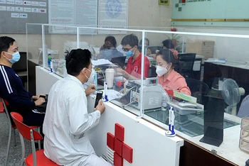 Bệnh nhân và người nhà làm thủ tục thanh toán bảo hiểm y tế tại Bệnh viện Ung bướu Hưng Việt (Hà Nội). (Ảnh NGUYỄN ÐĂNG)