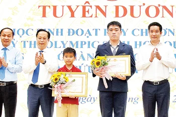 Các em Ðặng Tuấn Anh, Huỳnh Triệu Ðiền trong lễ tuyên dương những gương mặt học sinh tiêu biểu của ngành giáo dục và đào tạo Hà Nội. (Ảnh HÀ THÀNH)