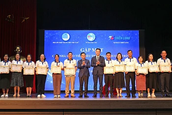 Thứ trưởng, Phó Chủ nhiệm Ủy ban Dân tộc Nông Quốc Tuấn và Phó Chủ tịch Thường trực Hội Liên hiệp thanh niên Việt Nam Nguyễn Kim Quy (thứ 8 và 9 từ trái sang) trao Kỷ niệm chương “Vì sự nghiệp phát triển các dân tộc” tặng một số đại diện giáo viên được tuyên dương.