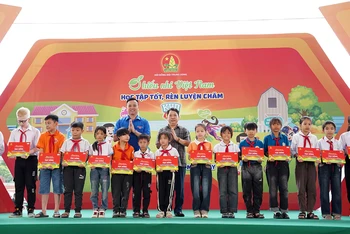Phó Chủ tịch Hội đồng Đội Trung ương, Giám đốc Trung tâm Hỗ trợ và Phát triển thiếu nhi Việt Nam Lê Anh Quân (bên trái, hàng sau) cùng đại diện Ban tổ chức Ngày hội trao học bổng tặng thiếu nhi hoàn cảnh khó khăn.