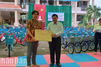 Đại diện Câu lạc bộ Toyohashi Golden Rotary-Nhật Bản trao bảng tượng trưng tặng 70 xe đạp cho học sinh có hoàn cảnh khó khăn Trường Tiểu học Nguyễn Thị Minh Khai cho lãnh đạo Ủy ban nhân dân huyện Buôn Đôn.