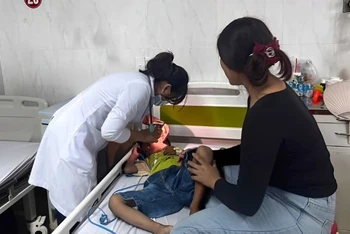 Bác sĩ khoa Nhi tổng hợp, Bệnh viện đa khoa vùng Tây Nguyên thăm khám cho bệnh nhi hóc dị vật đường thở. Ảnh: Quang Nhật.