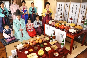 Một gia đình Hàn Quốc mặc trang phục truyền thống chuẩn bị lễ cúng tổ tiên trong Tết Chuseok (Ảnh: Tagstory)