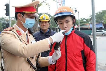 Cảnh sát giao thông Hà Nội kiểm tra nồng độ cồn theo đúng quy định của Bộ Y tế. Ảnh: VIỆT CƯỜNG
