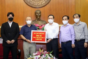 Đồng chí Trần Thanh Mẫn tiếp nhận ủng hộ từ HLV Park Hang Seo. Ảnh: Kỳ Anh.