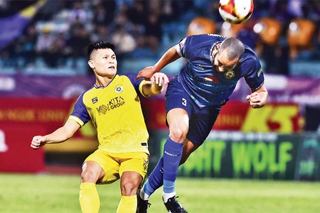 Hà Nội FC (áo vàng) thua MerryLand Quy Nhơn Bình Ðịnh trên sân nhà. (Ảnh TRẦN HẢI) 