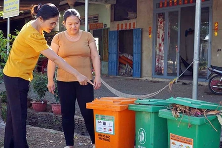 Cán bộ Hội Liên hiệp Phụ nữ xã Lang Minh, huyện Xuân Lộc, tỉnh Đồng Nai hướng dẫn người dân phân loại rác tại nguồn. (Ảnh MẠNH THÌN)