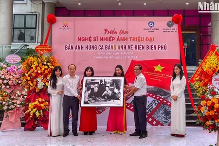 Đạo diễn Triệu Tuấn (người cầm ảnh bên phải) đại diện gia đình cố Nghệ sĩ nhiếp ảnh Triệu Đại trao tặng bộ ảnh cho Bảo tàng Phụ nữ Việt Nam.