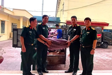 Đại diện cán bộ Ban Chỉ huy quân sự huyện Nậm Pồ trao bí xanh để các bộ phận chế biến phục vụ lực lượng diễu binh, diễu hành.