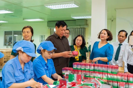Thứ trưởng Đỗ Xuân Tuyên và Tổng Giám đốc Công ty cổ phần Dược phẩm OPC Phạm Thị Xuân Hương tham quan dây chuyền đóng gói sản phẩm Siro HoAstex.