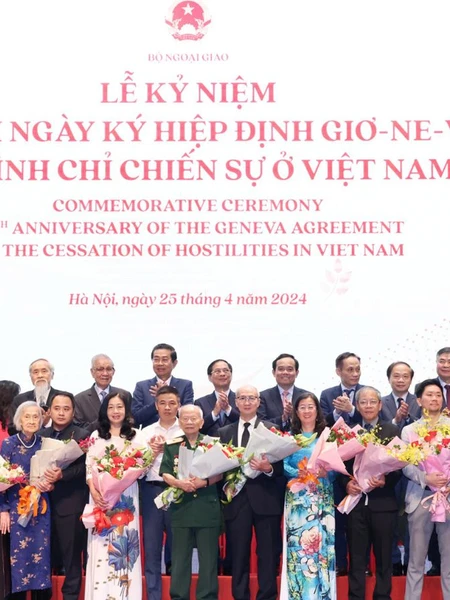 Trưởng Ban Đối ngoại Trung ương Lê Hoài Trung và Phó Thủ tướng Trần Lưu Quang tặng hoa, chúc mừng đại diện gia đình cán bộ tham gia phục vụ Hội nghị Geneve tại Lễ kỷ niệm.
