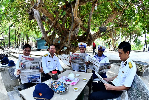 Các cán bộ, chiến sĩ hải quân trên đảo Sinh Tồn (huyện đảo Trường Sa, tỉnh Khánh Hòa) đón đọc các ấn phẩm của Báo Nhân Dân. (Ảnh ĐĂNG KHOA)